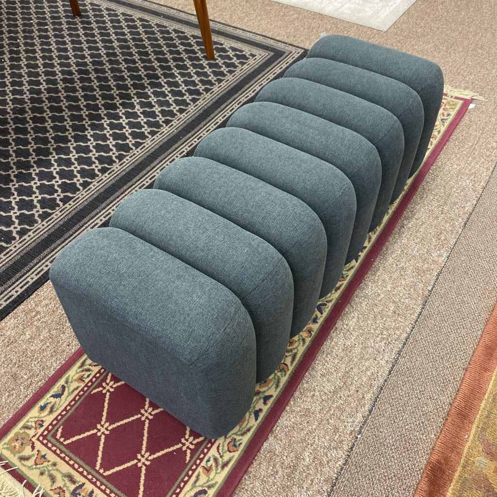 Row of blue ottomans on a patterned rug