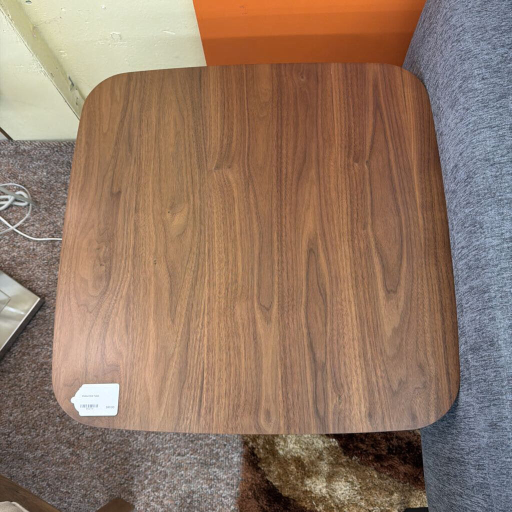 Wooden stool with a label on a carpeted floor