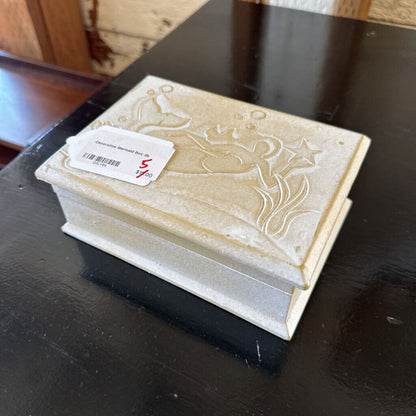 Decorative stone box with intricate carvings on a dark surface