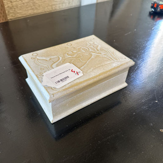 Decorative wooden box with intricate carvings on a dark surface