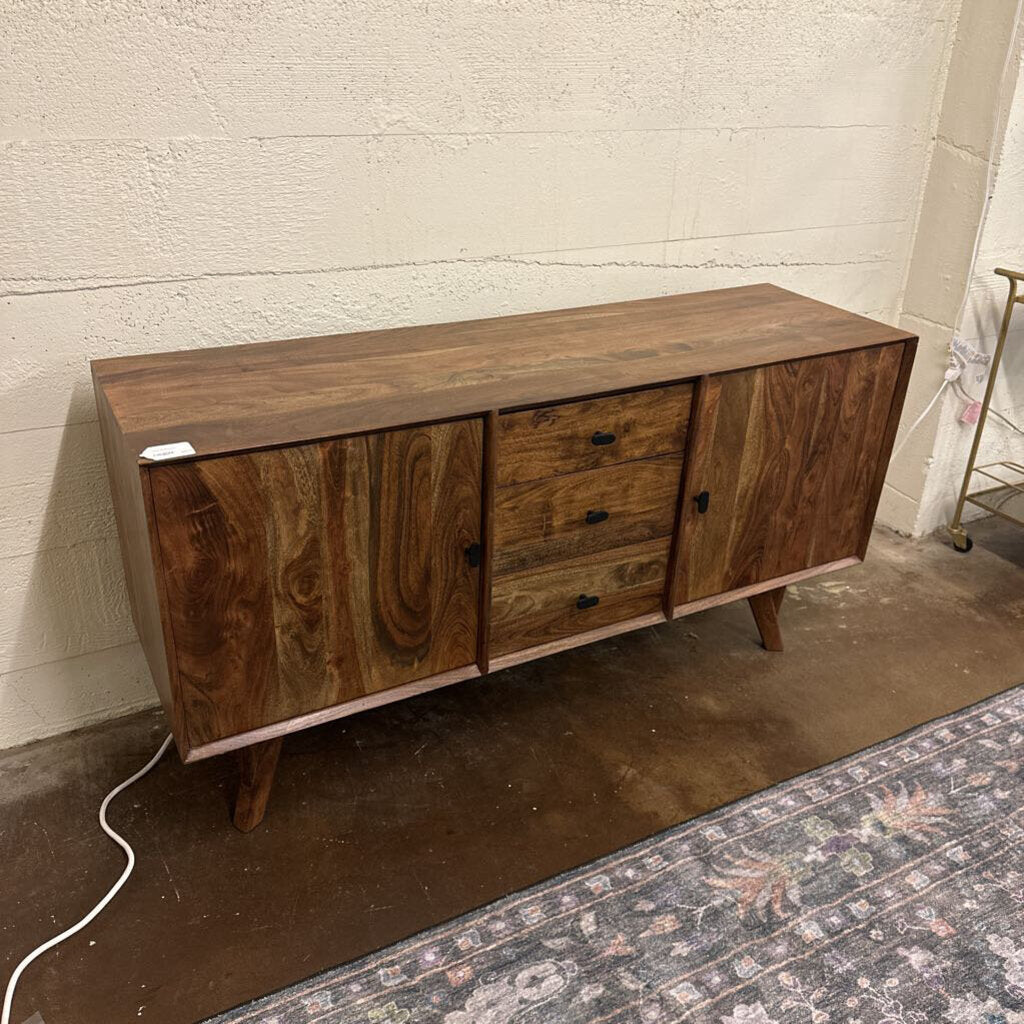 Wooden sideboard with three drawers against a white wall.
