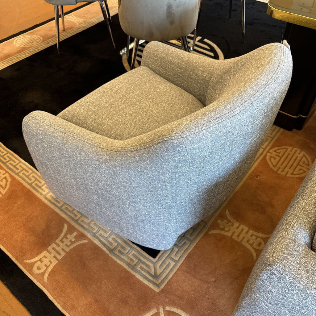 Gray armchair on a patterned rug with a blurred background