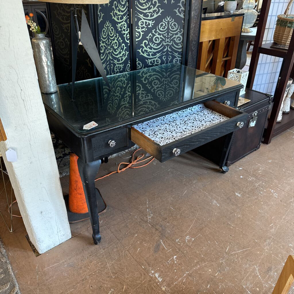 Black vanity table with open drawer in a room setting