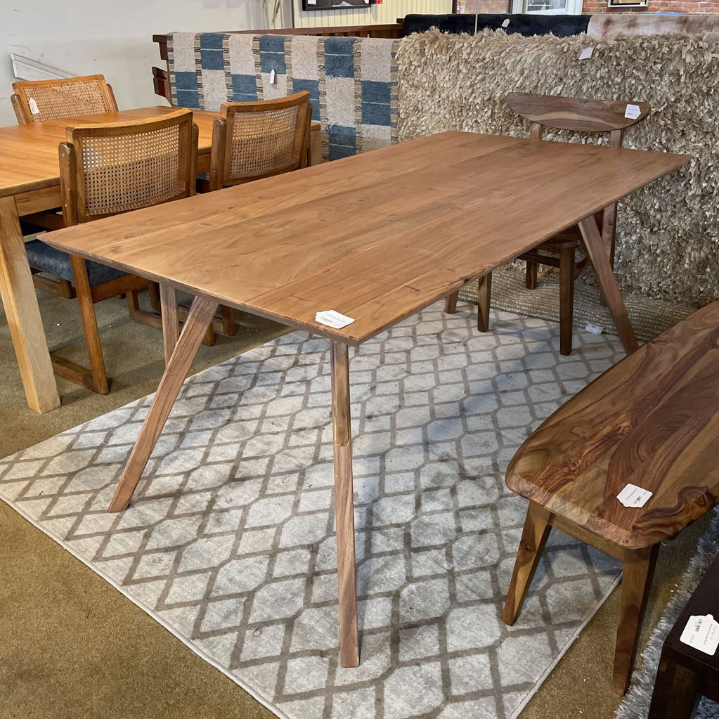 Wooden dining table with chairs in a showroom setting