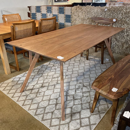 Wooden dining table with chairs in a showroom setting