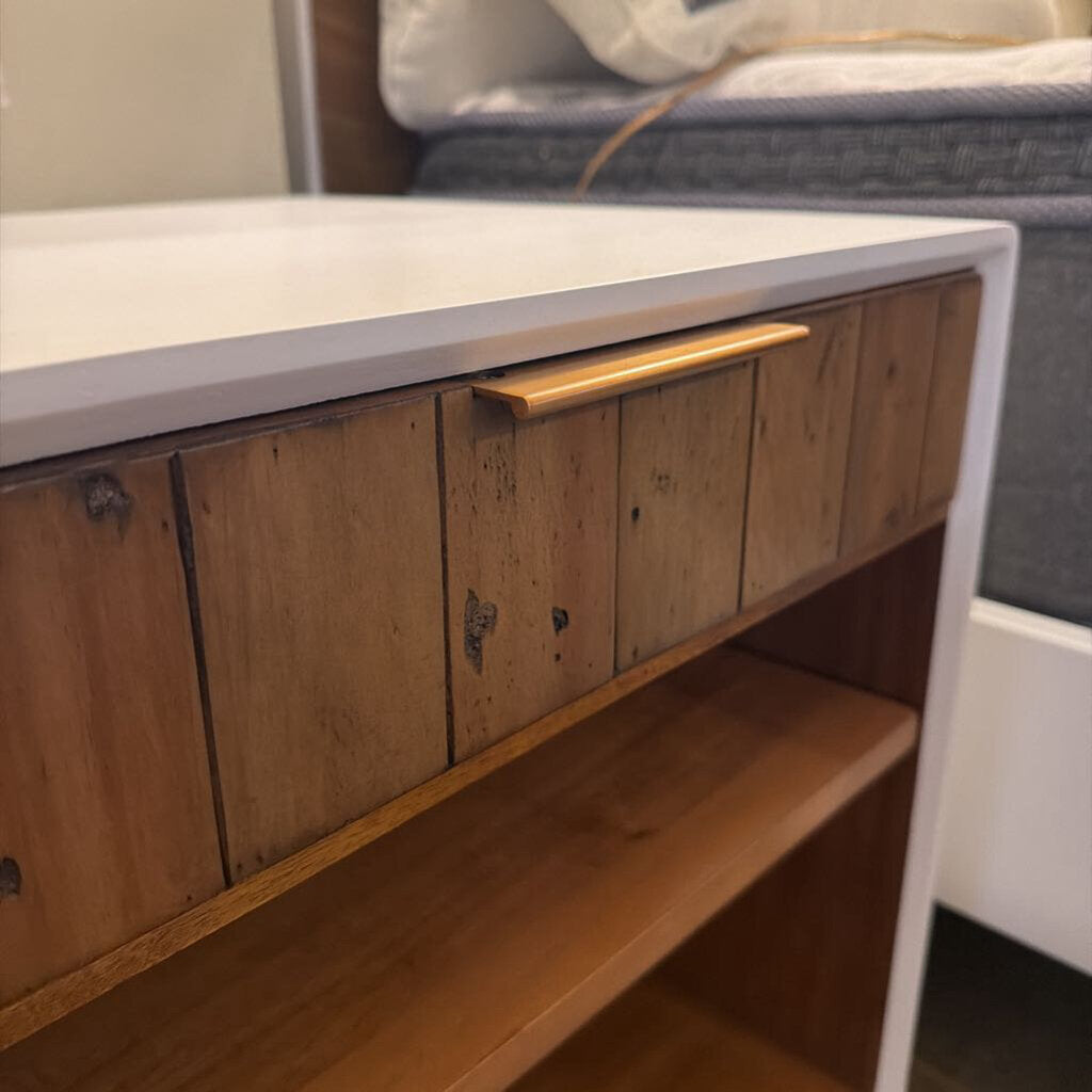 Wooden drawer with a metal handle on a white countertop.