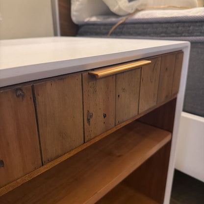 Wooden drawer with a metal handle on a white countertop.