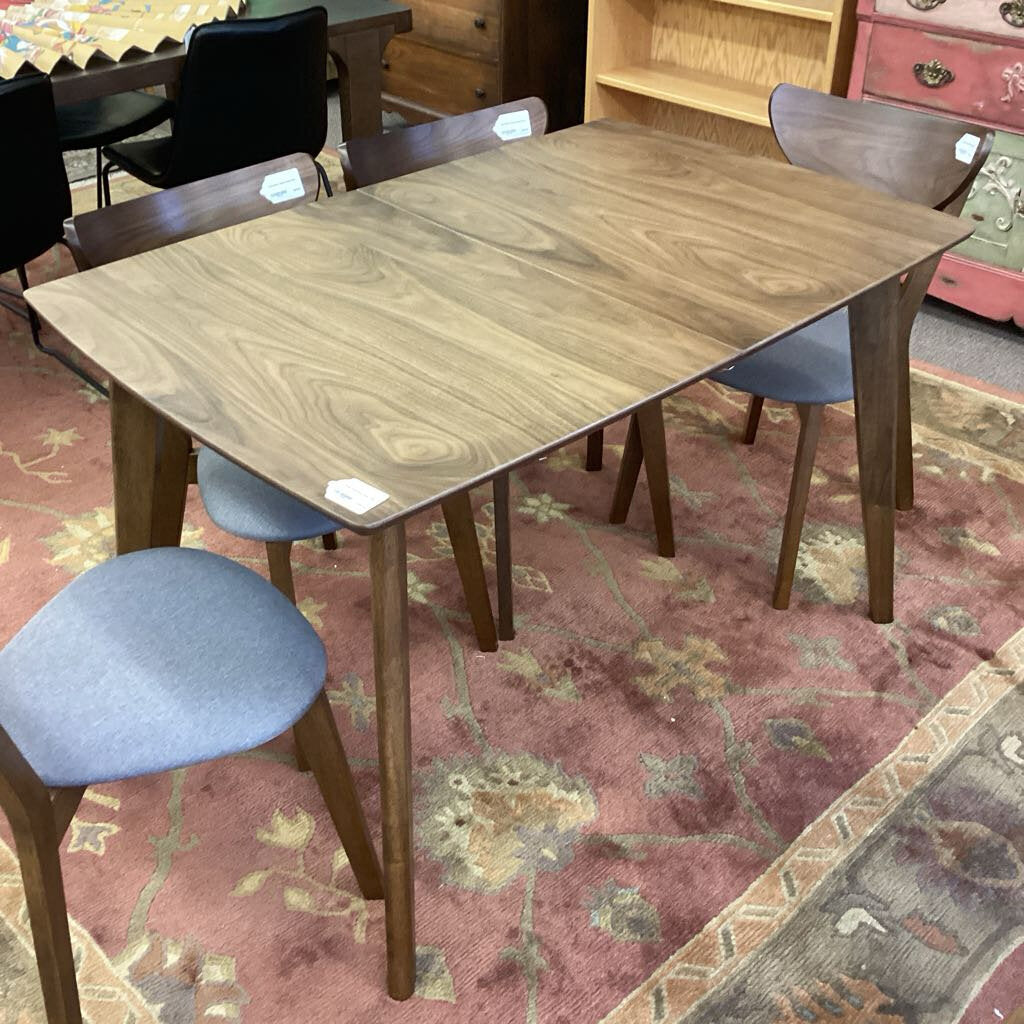 Wooden dining table with chairs on a patterned rug