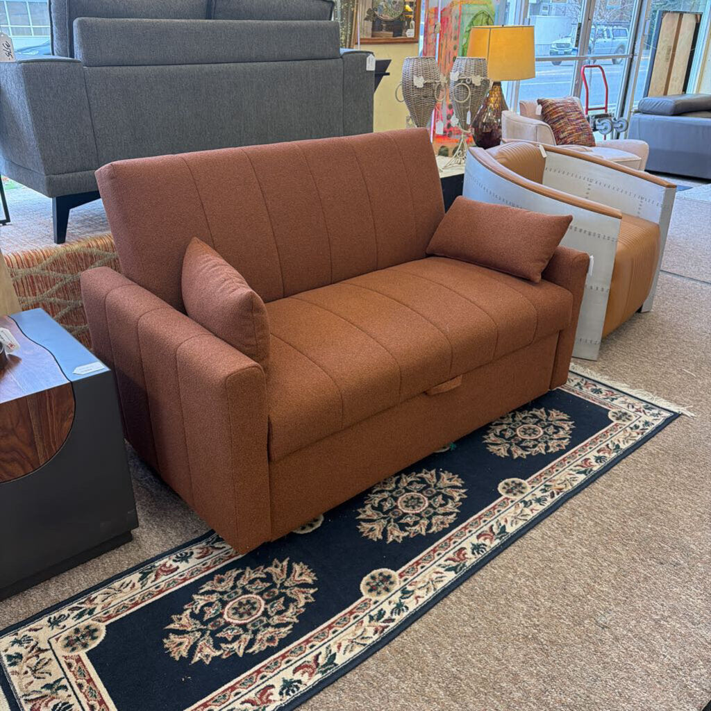 Brown sofa with cushions on a patterned rug in a furniture store