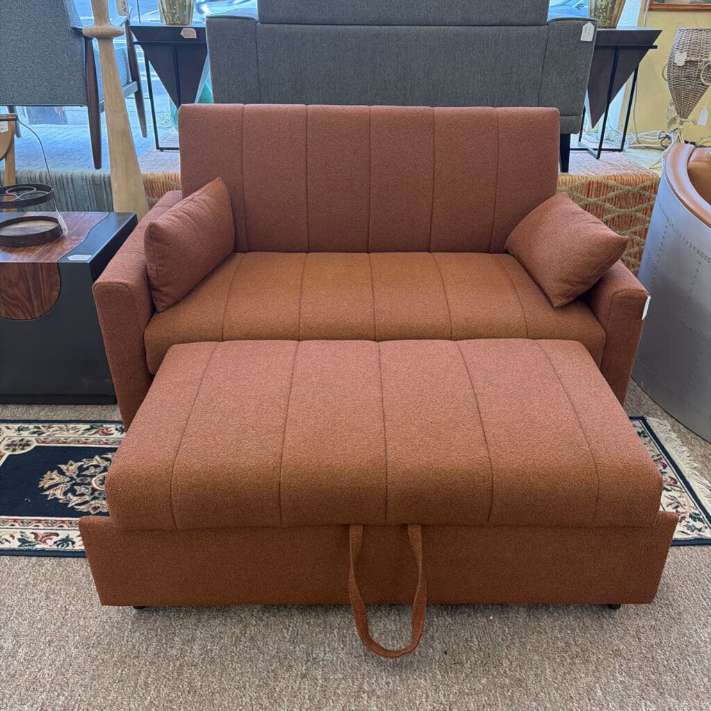 Brown sectional sofa with ottoman in a showroom setting