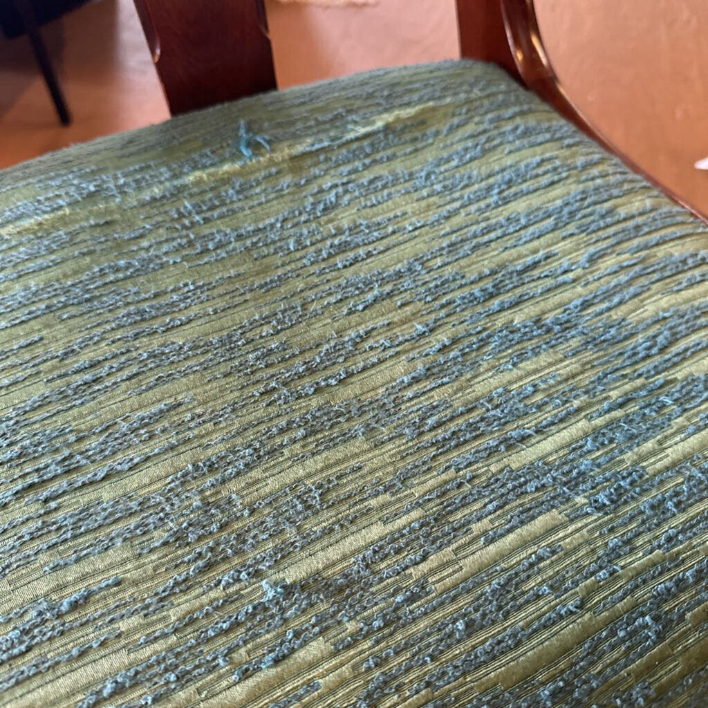 Textured green fabric surface with visible wear and tear