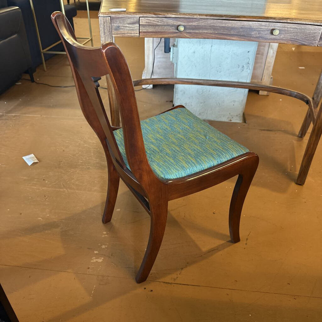 Wooden chair with a green cushion on a wooden floor.