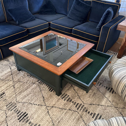 Blue sectional sofa with a coffee table featuring a hidden compartment on a patterned rug.