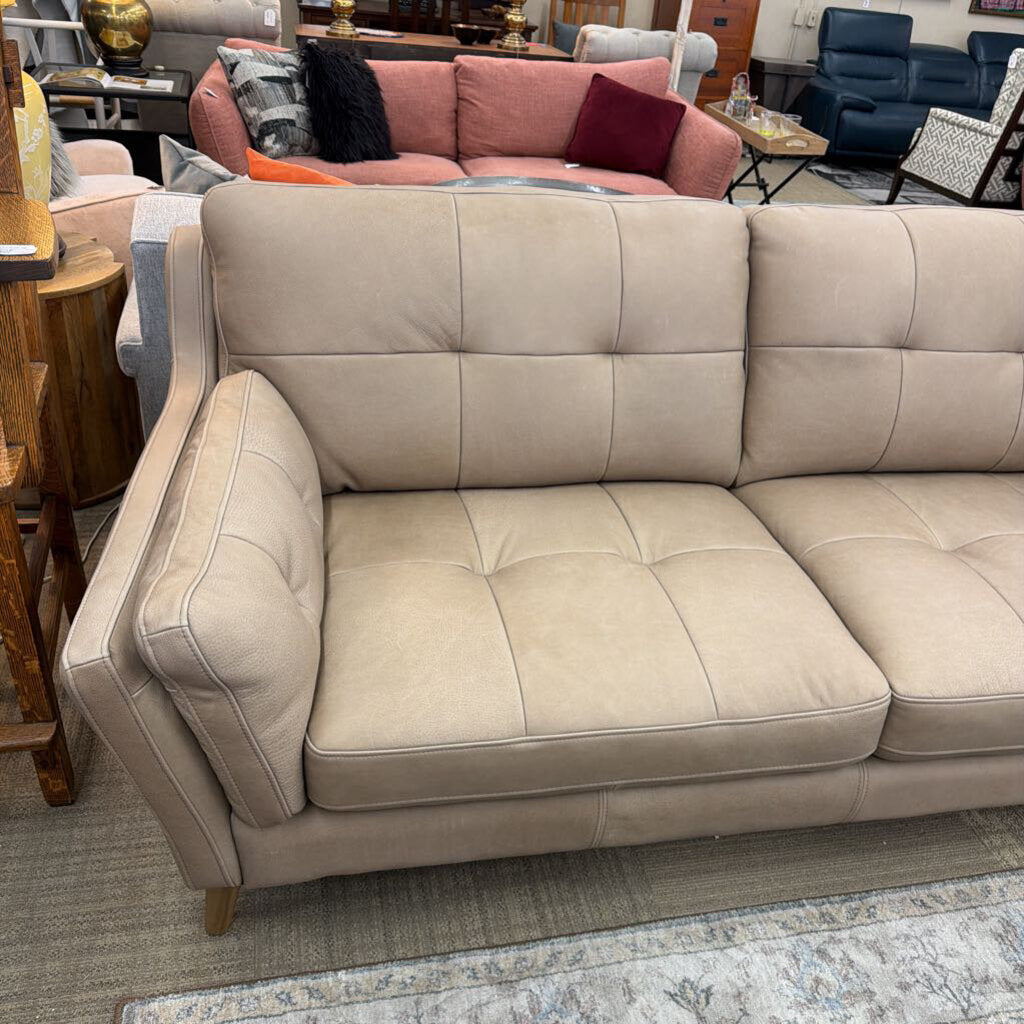 Beige sectional sofa in a room with other furniture.