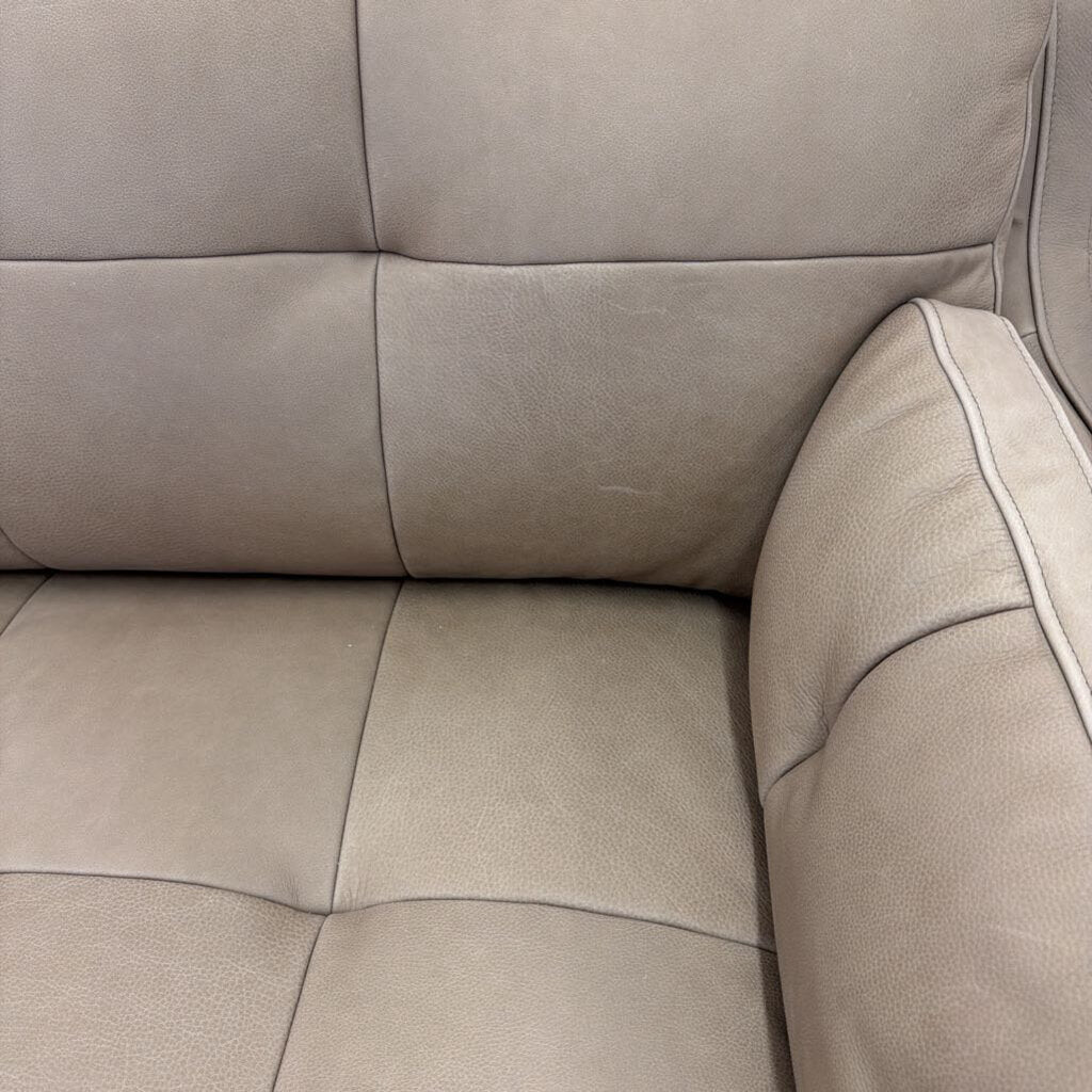 Close-up of a beige leather sofa with visible stitching