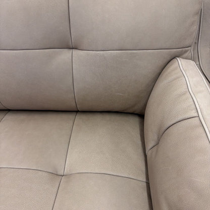 Close-up of a beige leather sofa with visible stitching