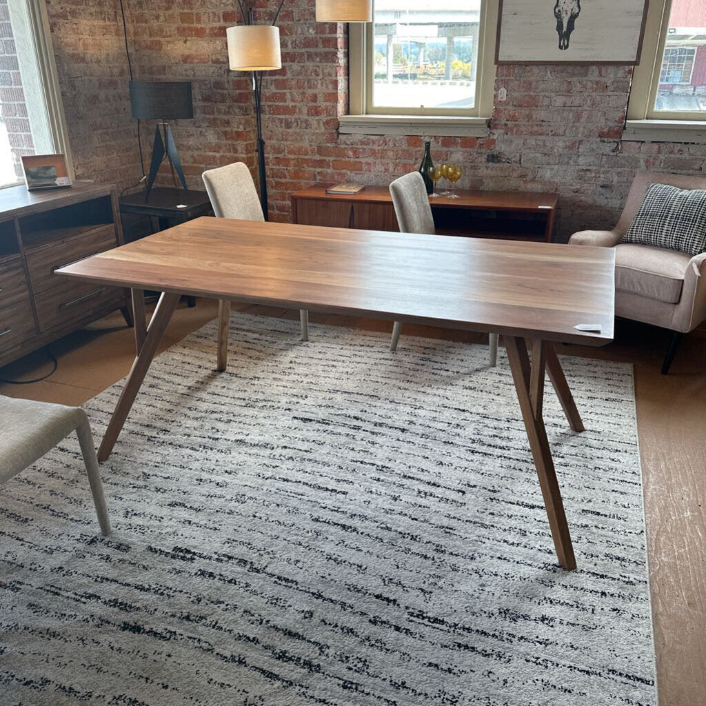 Wooden dining table in a room with chairs and a rug