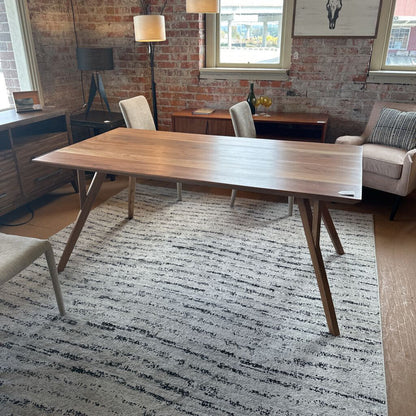 Wooden dining table in a room with chairs and a rug