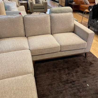 Beige sectional sofa in a room with other furniture.