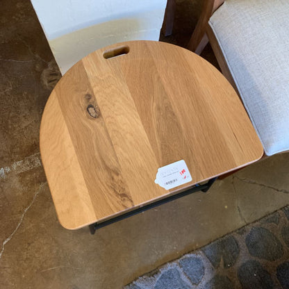 Wooden stool with a label on a stone floor