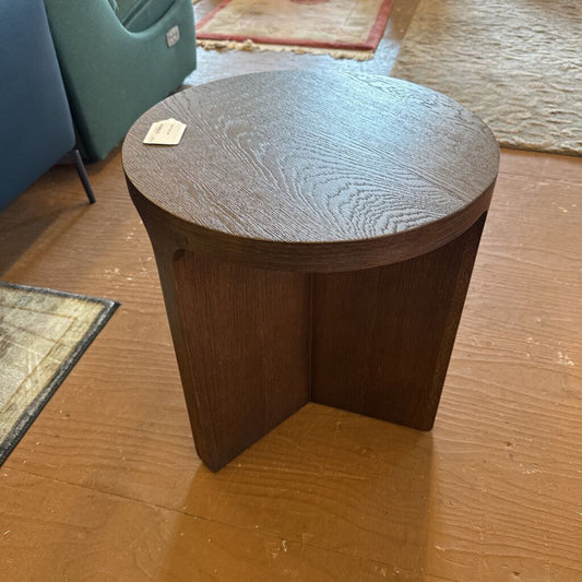 Wooden side table on a wooden floor with a tag attached