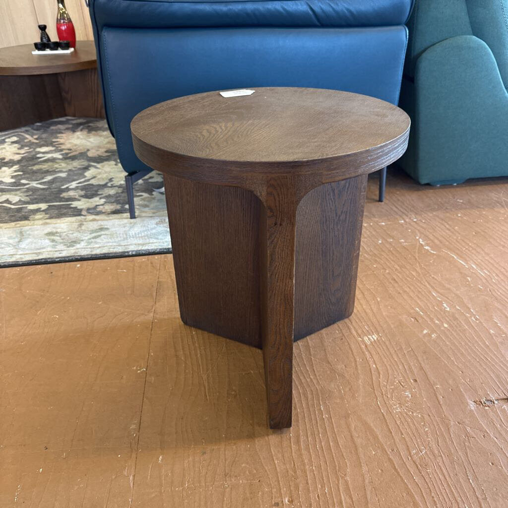 Wooden side table on a wooden floor with a blue sofa in the background