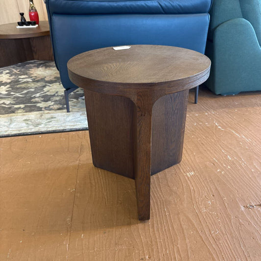 Wooden side table on a wooden floor with a blue sofa in the background