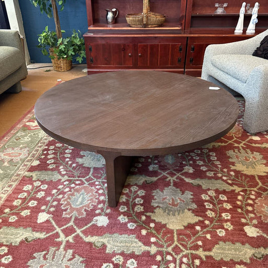 Wooden coffee table in a living room with a patterned rug and furniture.