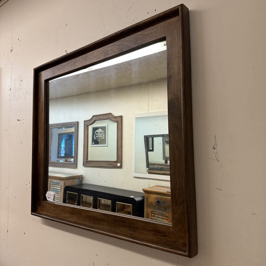 Wooden-framed mirror on a beige wall