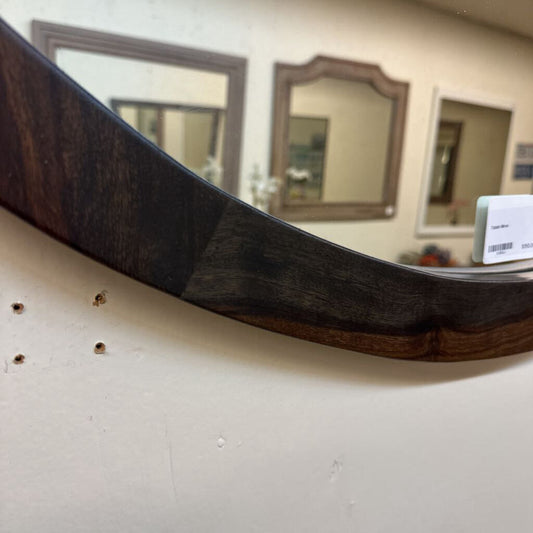 Wooden mirror with a dark brown frame on a white wall.