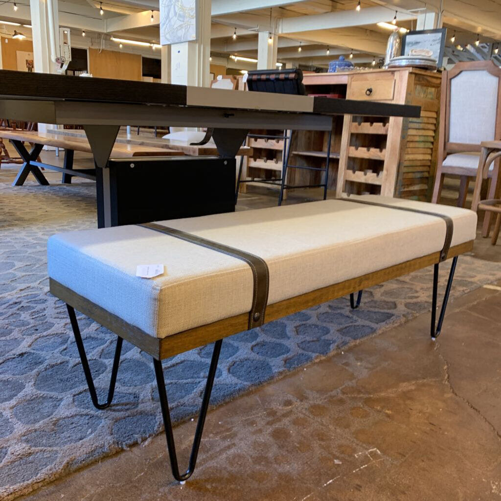 Modern bench with wooden frame and cushioned seat in a showroom setting