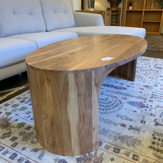 Wooden coffee table in a living room setting with a sofa and rug.