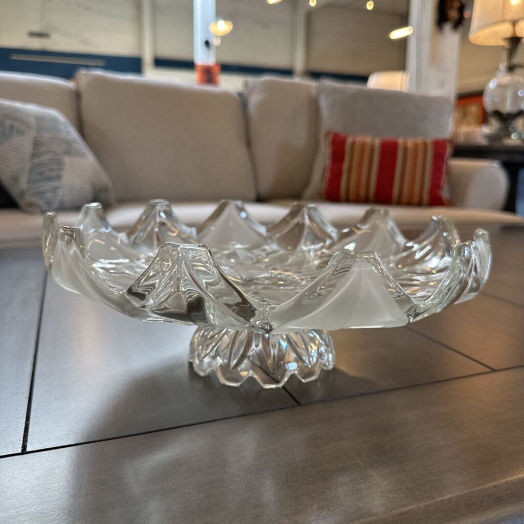 Clear glass bowl on a reflective surface with a blurred indoor background