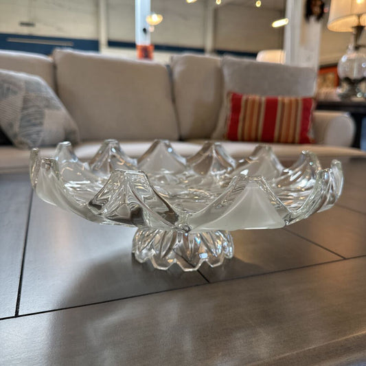 Clear glass bowl on a reflective surface with a blurred indoor background