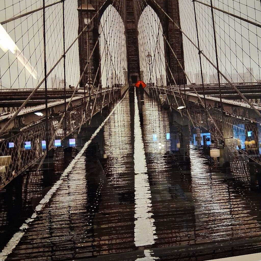 Reflections on the surface of the Brooklyn Bridge at night.