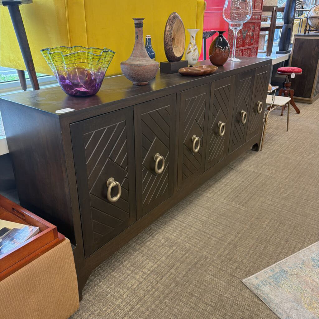 Dark wooden sideboard with decorative items on top in a store setting