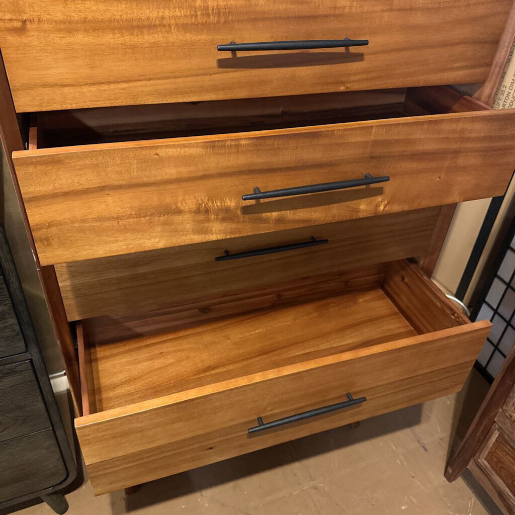 Wooden dresser with open drawer showing black handles.