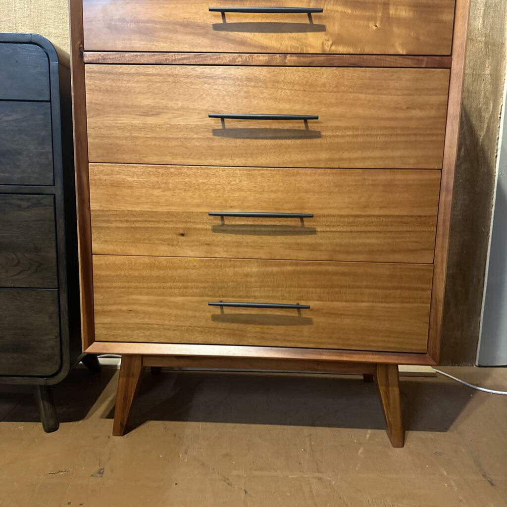 Wooden dresser with four drawers on a wooden floor.