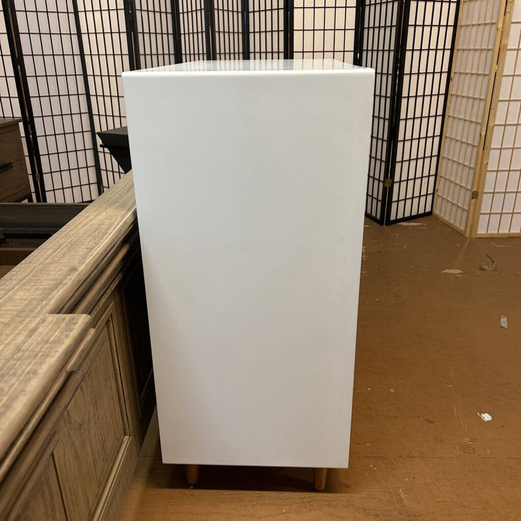 White cabinet against a black and white patterned wall