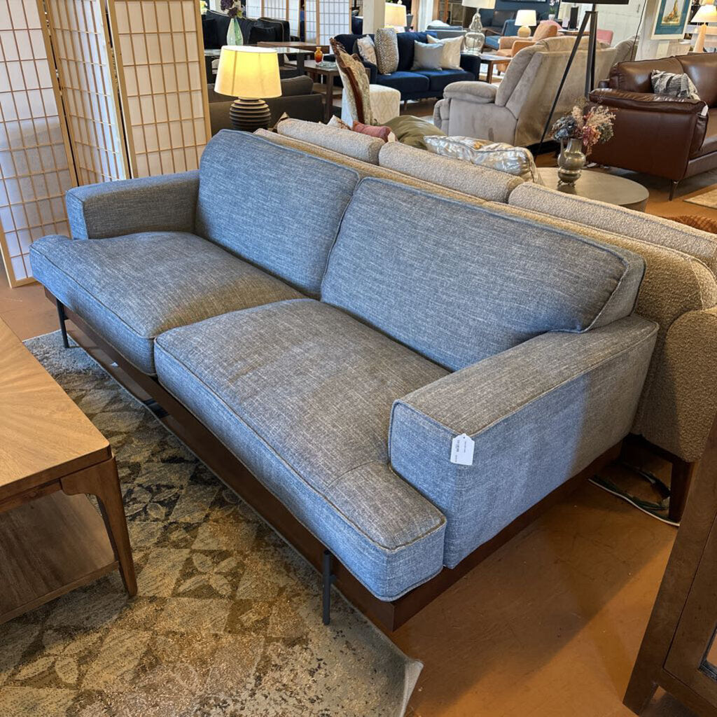 Gray sofa in a showroom with other furniture in the background