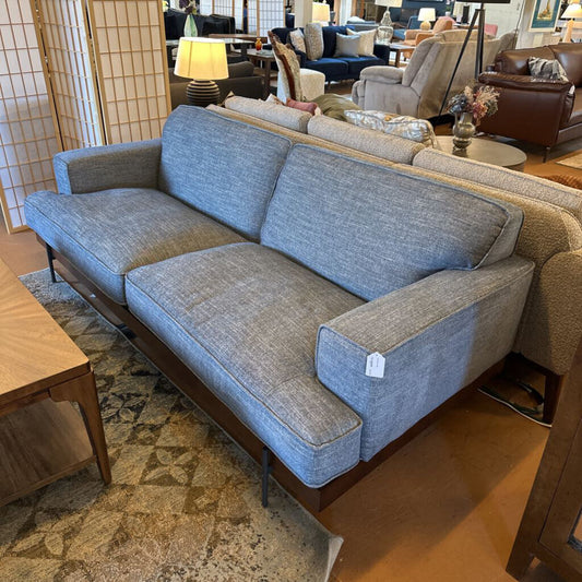 Gray sofa in a showroom with other furniture in the background