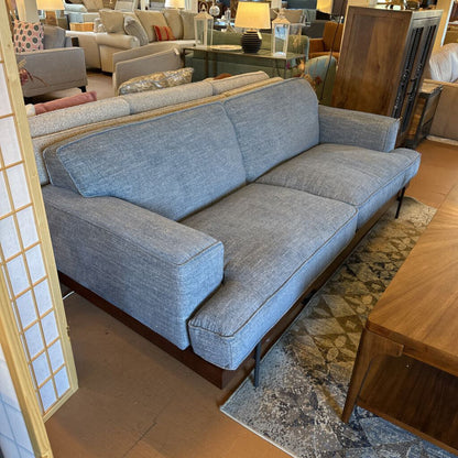 Gray sofa in a room with furniture and decor