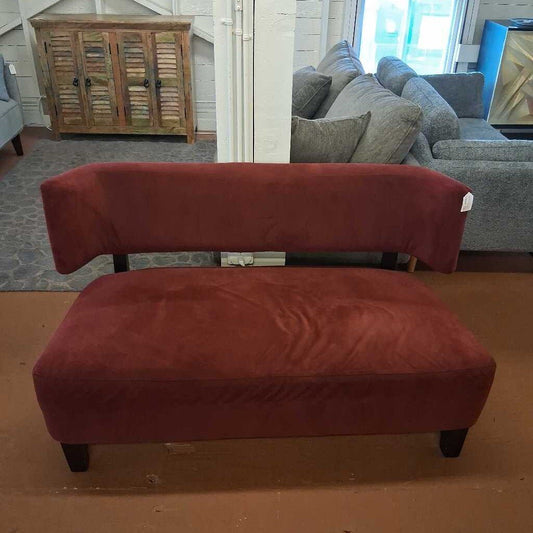 Red bench in a room with gray sofa and wooden cabinet