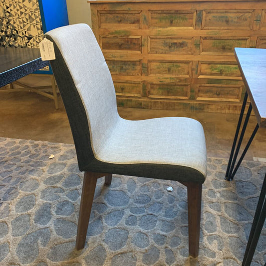 Chair with a wooden frame and white cushion on a stone floor
