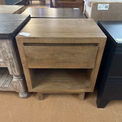 Wooden side table with a drawer and open shelf in a store setting