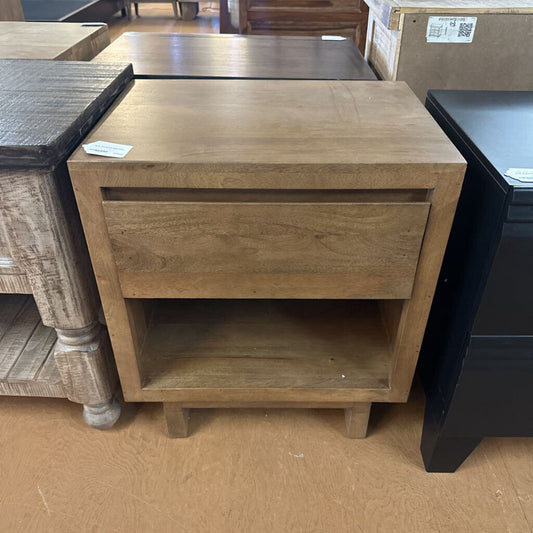 Wooden side table with a drawer and open shelf in a store setting