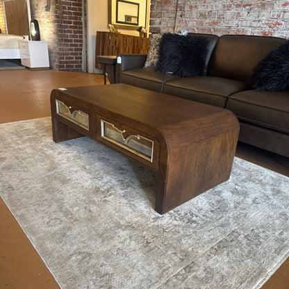 Brown leather sofa with a wooden coffee table in a living room setting.