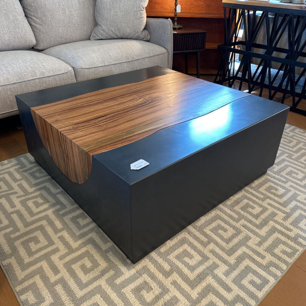 Modern coffee table with wooden top and black base in a living room setting