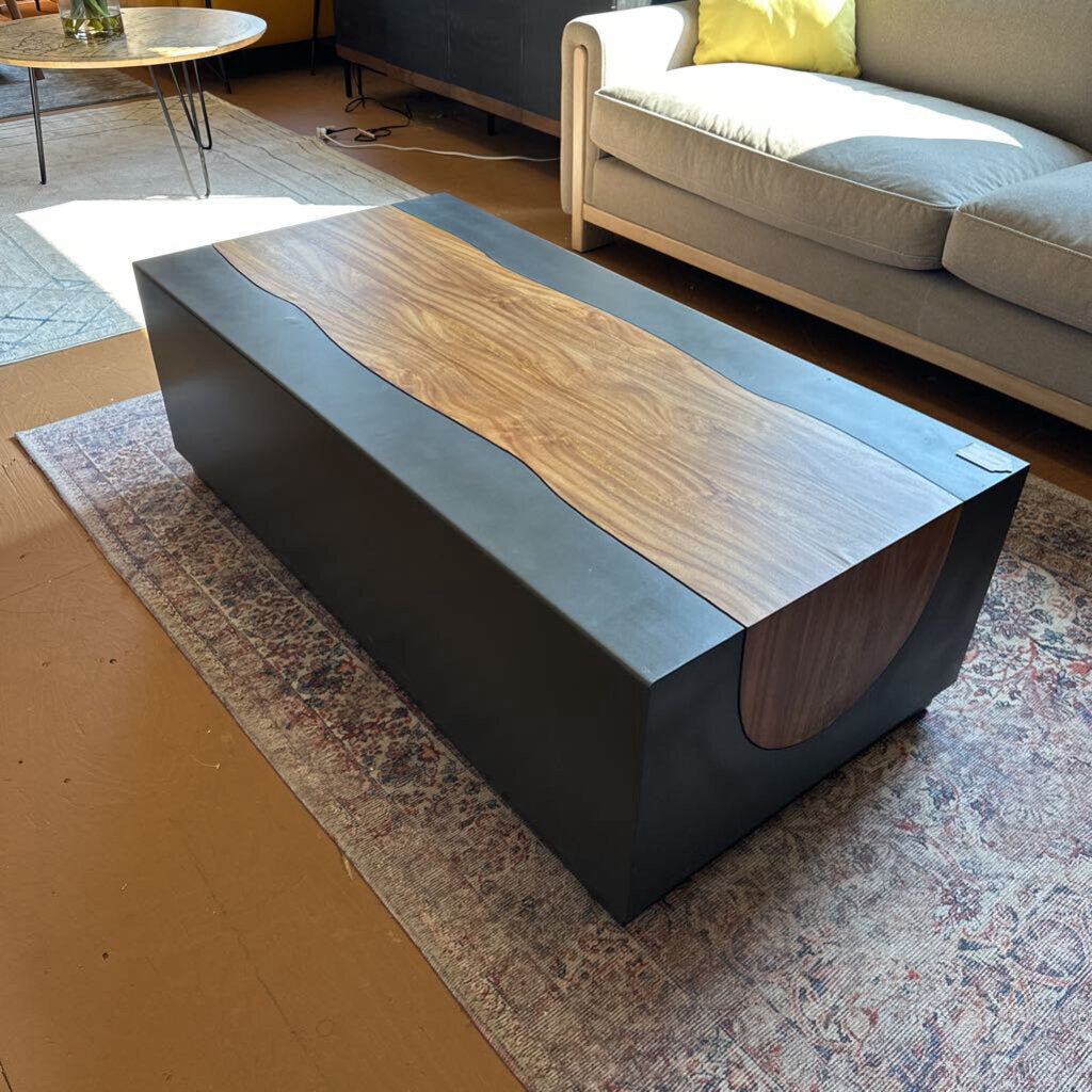 Modern coffee table with wooden top and black base in a living room setting