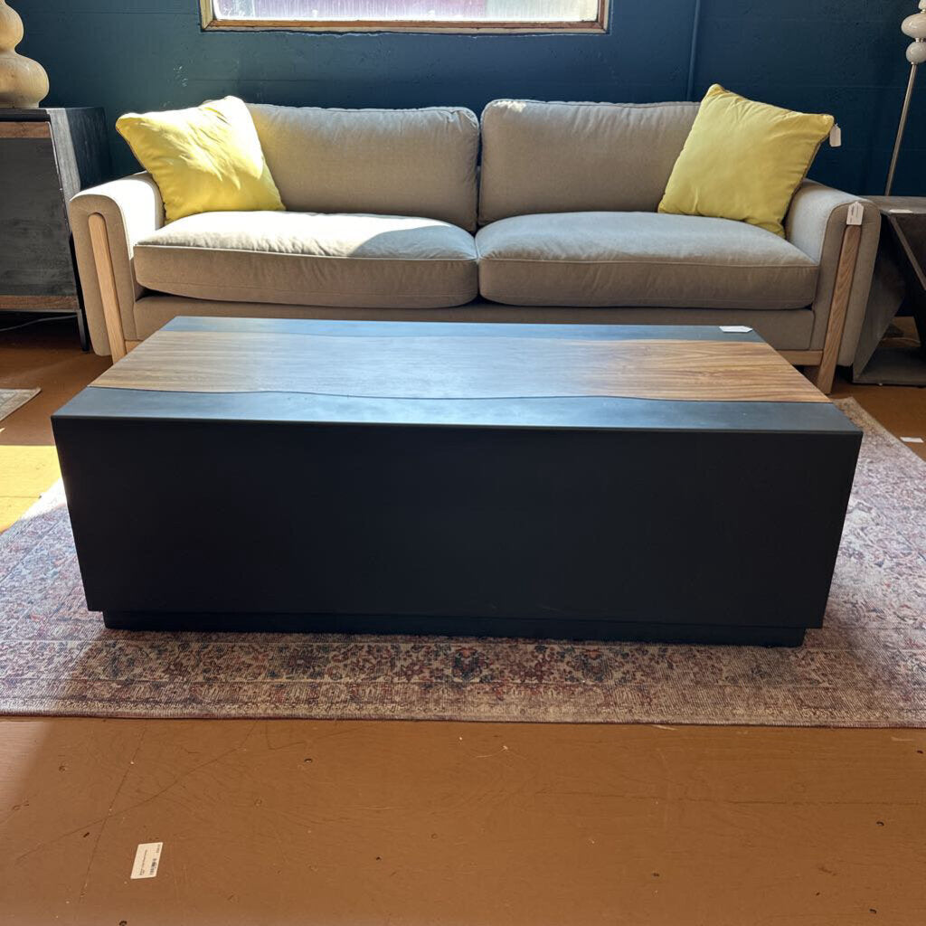 Gray sofa with yellow cushions and a black and wooden coffee table in a room.